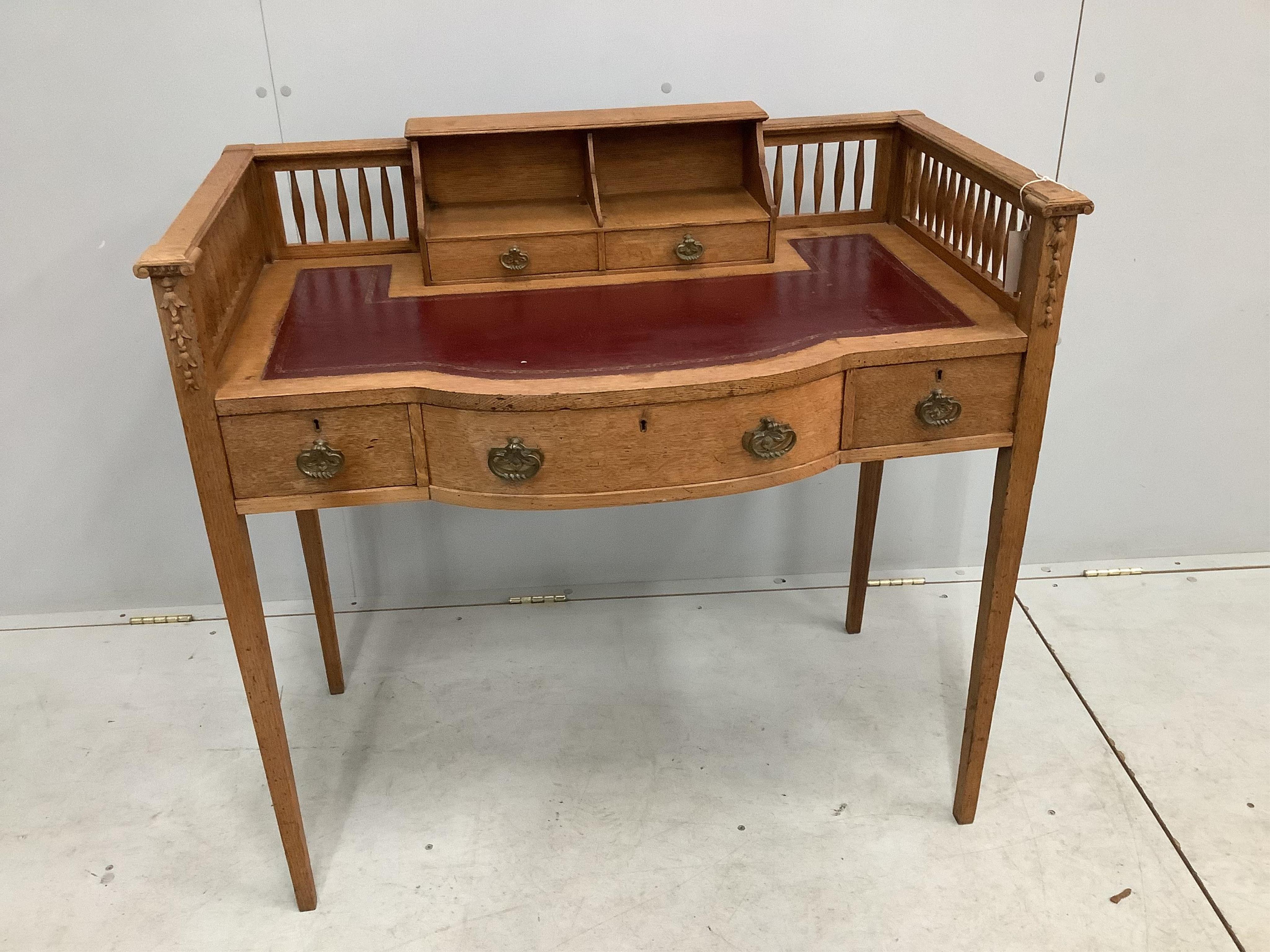 An early 20th century oak bow front writing table, width 95cm, depth 53cm, height 91cm. Condition - fair to good